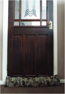 Brown front door with a draft excluder