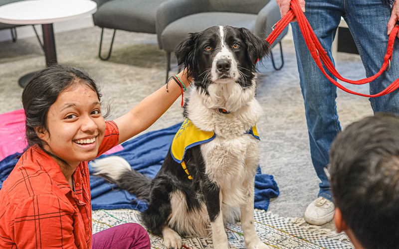 a photo of a student with a dog at a guild event