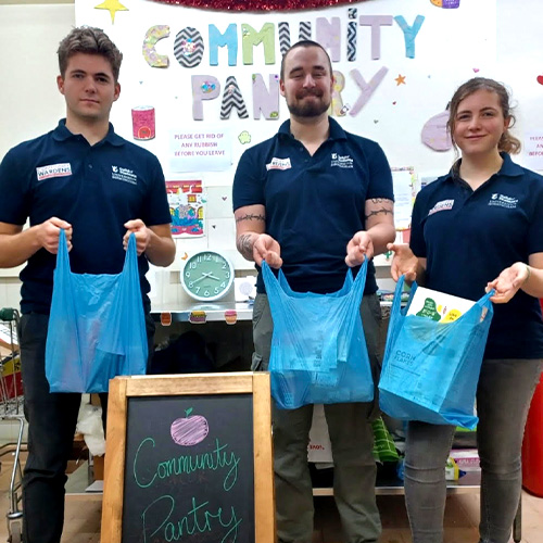 A picture of the guild pantry team holding bags