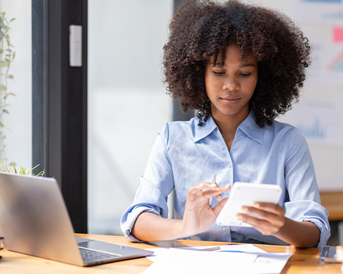 a students with a laptop looking at a notebook