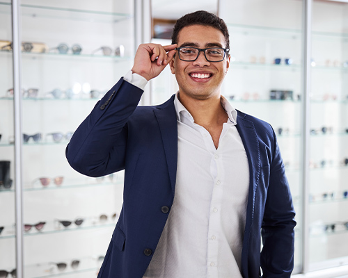a photo of a student in an opticians wearing glasses smiling