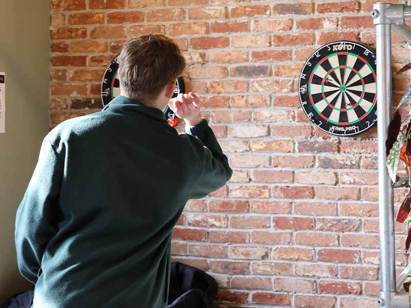 an image of students playing darts in joe's bar