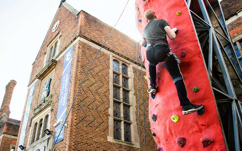 a student rock climbing outside of the guild