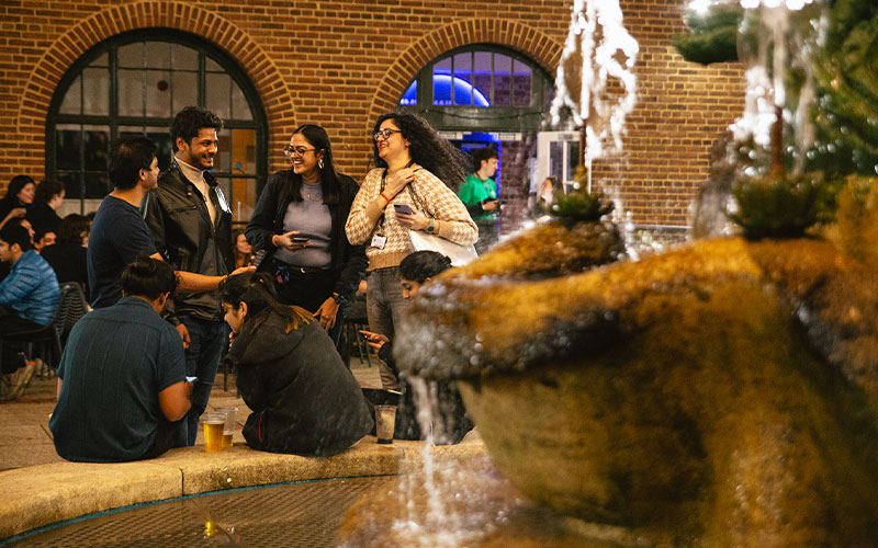 a wide shot of students by the mermaid fountain
