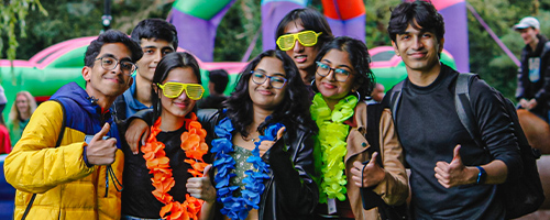 an image of students smiling at an outdoor event