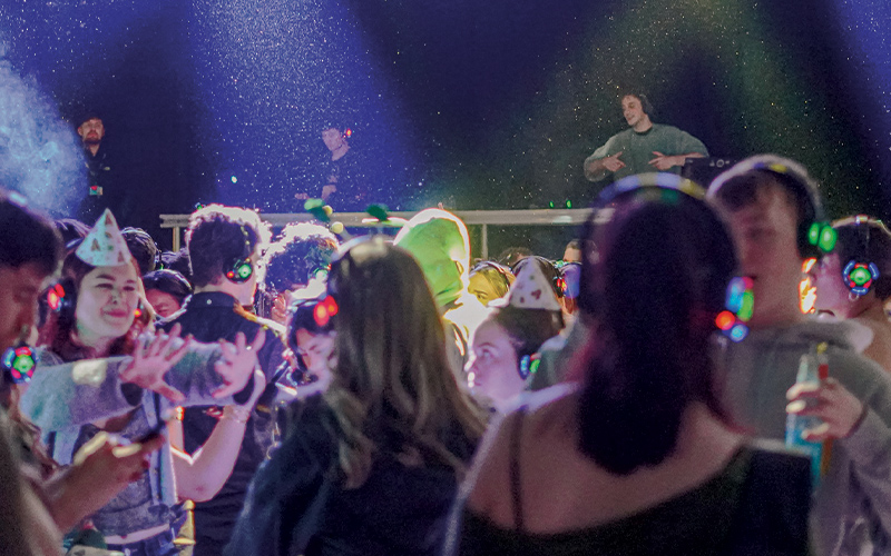 students dancing with a dj in the background