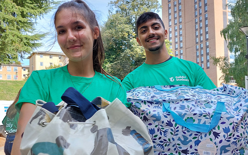a photo of students carrying boxes of luggage