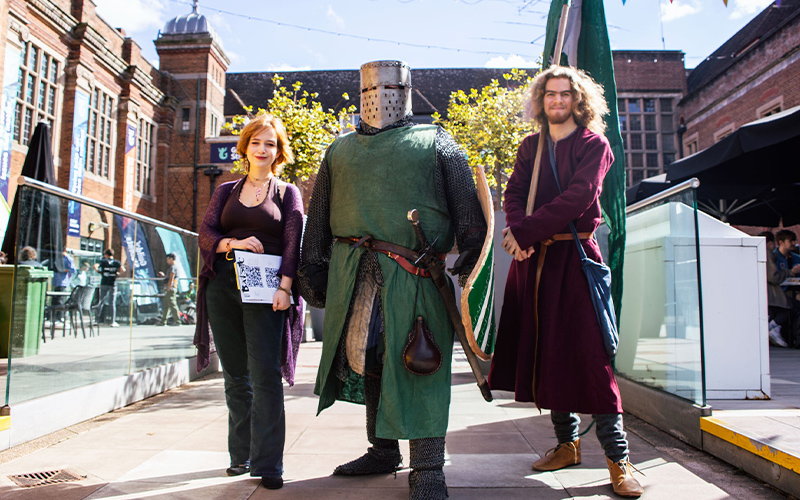 students stood outside in mermaid square dressed in chain mail