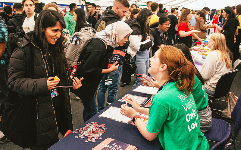 student talking to student groups at socities fair